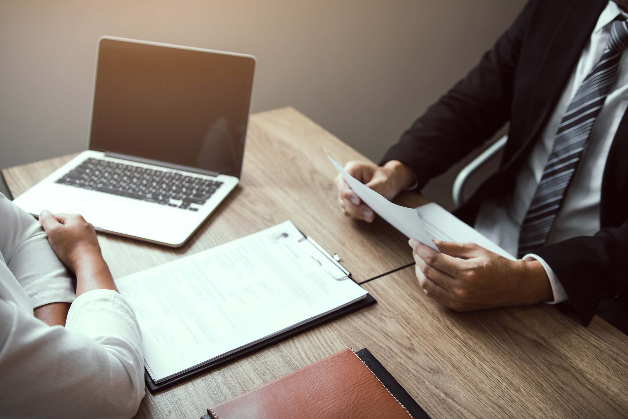 Job applicants are holding a resume document in the job interview room, job interview concept.